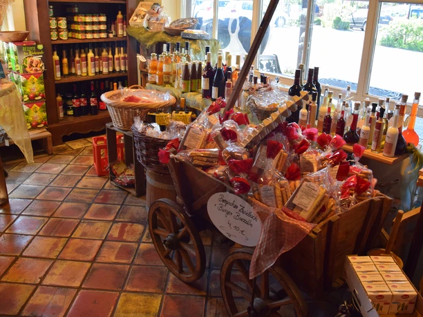 Hofladen Hielscher Hof Ein einladender Hofladen mit Körben voller regionaler Spezialitäten und Getränken auf rustikalem Fliesenboden.