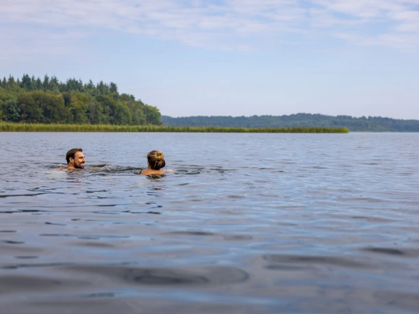 Zwei Menschen baden im Schaalsee bei Seedorf.