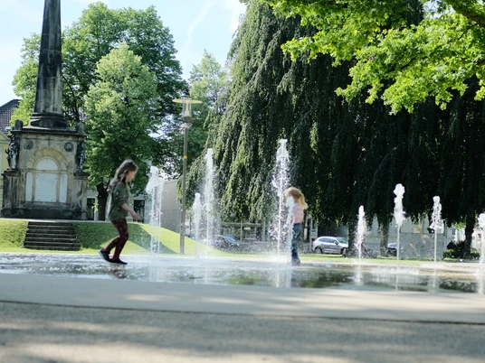 Kaiser-Wilhelm-Platz Detmold Zwei Kinder spielen in den sprudelnden Wasserfontänen des Kaiser-Wilhelm-Platzes in Detmold.