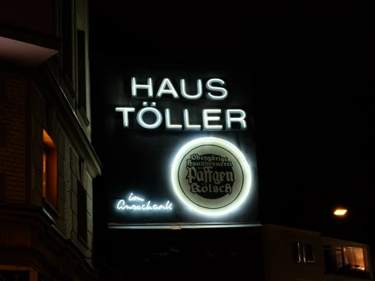 House Töller neon Neonbeleuchtetes Schild des "Haus Töller" bei Nacht mit dem Logo der Brauerei Päffgen Kölsch.Neon-illuminated sign of "Haus Töller" at night with the logo of the Päffgen Kölsch brewery.