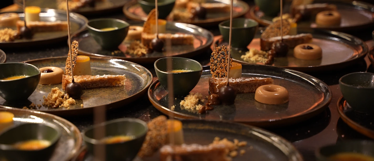 Bergische Genusstage Eine Reihe von kunstvoll angerichteten Desserttellern mit süßen Pralinen und dekorativen Garnierungen.