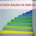 bunte_Treppe_©_Andrey_Navrotskig_stock.adobe.com.jpg Eine Treppe mit Stufen in Regenbogenfarben, mit dem Text "Brücken bauen in den Beruf".