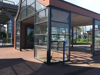 Trinkwasserspender am Bahnhof 2024_Tomke Lange.jpg Ein moderner Trinkwasserspender steht auf einem Bahnsteig; umgeben von Glaswänden und Backsteinstrukturen strahlt er Frische aus.