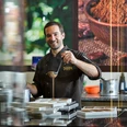 Chocolatier Linus Kässer Ein Chocolatier in Arbeitskleidung gießt Schokolade in Formen.