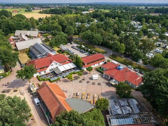 Luftaufnahme eines weitläufigen Campingplatzes inmitten grüner Bäume und Natur.Aerial view of a spacious campsite surrounded by green trees and nature.Luftfoto af en rummelig campingplads omgivet af grønne træer og natur.Luchtfoto van een ruime camping omgeven door groene bomen en natuur.