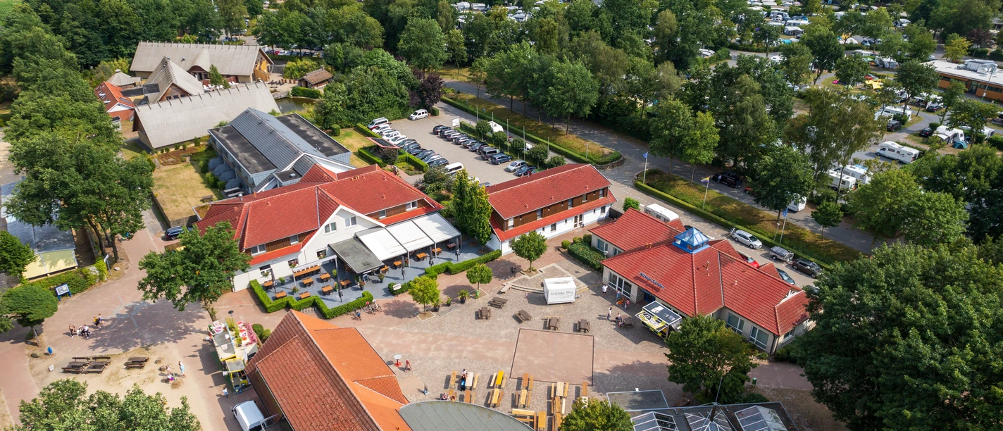 alfsee-drohne(c)tol-foto-jurjen-drenth (10).JPG Aerial view of a spacious campsite surrounded by green trees and nature.