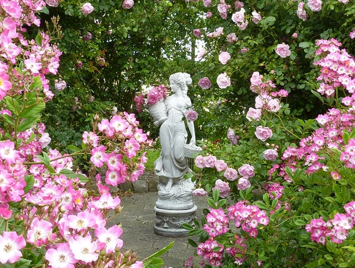 Rosenhaven-Frederiksgård_Haveskulpturen_i_et_væld_af_lyserødt