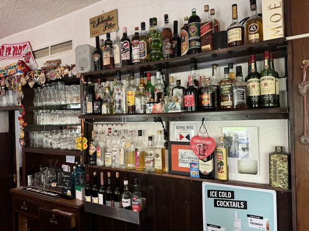 Zur Quelle der Strunde - Ansicht Bar <p>Eine gemütliche Bar mit Regalen voll verschiedener Spirituosen- und Likörflaschen.</p>