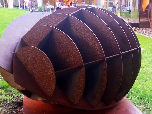 Harald A. Finke Pflanzendenkmal-Chloroplast-MItochondrium 2022 Das Bild zeigt eine faszinierende moderne Skulptur von Harald A. Finke im Jahr 2022, die organische Formen verkörpert und das Zusammenspiel von Chloroplasten und Mitochondrien thematisiert.