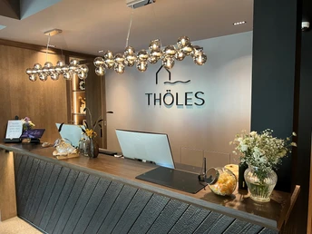 Empfangsbereich von Thöles Hotel in Bücken mit stilvollen Leuchten und einladender Dekoration.
