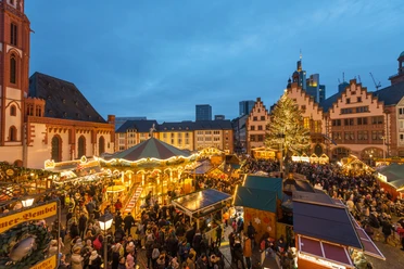 Illuminated Christmas market on the Römerberg with a carousel, a Christmas tree, and a large crowd