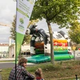 Green World Tour Cologne A father and child sit on a meadow in front of a green cow-shaped bouncy castle at the Green World Tour.