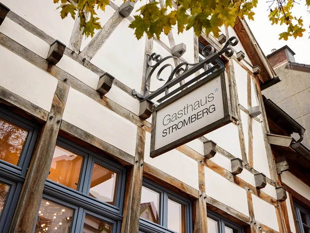 Gasthaus Stromberg, Waltrop Historisches Fachwerkgebäude mit dem Schild "Gasthaus Stromberg" in Waltrop, von Bäumen umgeben.