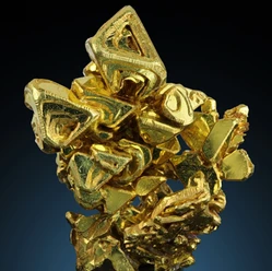 Goldene Kristalle in einem dynamischen Cluster vor dunkelblauem Hintergrund.