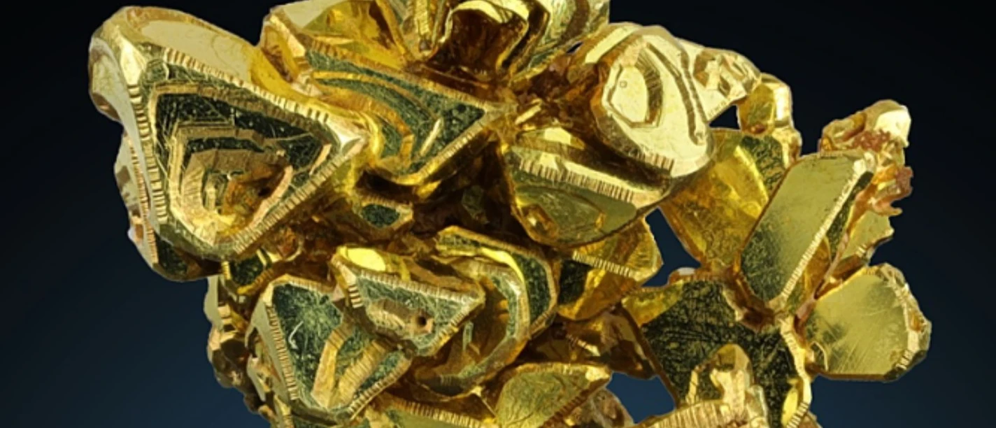 Goldene Kristalle in einem dynamischen Cluster vor dunkelblauem Hintergrund.