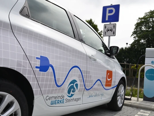 Mobilstation Steinhagen eAuto Ein Elektroauto der Gemeindewerke Steinhagen wird an einer Ladestation auf einem Parkplatz geladen.