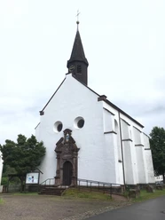 Katholische Kirche Blankenau Katholische Kirche Blankenau mit markantem Turm, umgeben von Bäumen und gepflastertem Weg.