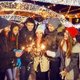 Happy friends with sparklers at a fair at christmas Teamfoto auf dem Weihnachtsmarkt: Personen halten Wunderkerzen in den HändenTeam photo at the Christmas market: people holding sparklers in their hands