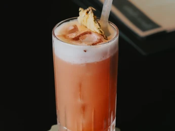 GG Grace Sling.jpg Orangener Cocktail "Grace Sling" in einem Glas zubereitetOrange Cocktail "Grace Sling" prepared in a glass