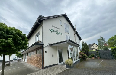 Hotel Garni Alt Refrath - Außenansicht Hotel Garni Alt-Refrath mit moderner Fassade, gepflegtem Vorplatz und grüner Umgebung.