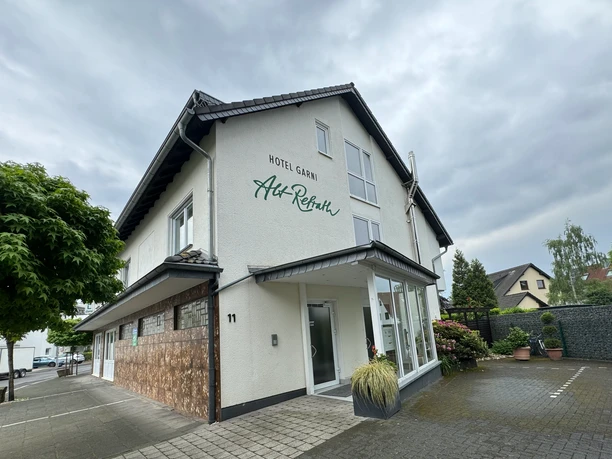 Hotel Garni Alt Refrath - Außenansicht Hotel Garni Alt-Refrath mit moderner Fassade, gepflegtem Vorplatz und grüner Umgebung.