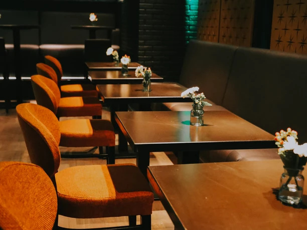 GG_Nov_23_9.jpg A row of wooden chairs and tables in dim lighting