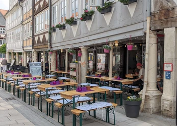 Bistro Provence Bierzelttische mit Sitzpolstern und liebevoller Deko vor Fachwerkhäusern