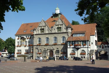 Rathaus Bergisch Gladbach Historisches Rathaus mit roten Ziegeldächern und Blumendekoration auf einem sonnigen Marktplatz.