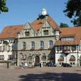 Rathaus Bergisch Gladbach Historisches Rathaus mit roten Ziegeldächern und Blumendekoration auf einem sonnigen Marktplatz.