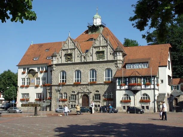 Rathaus Bergisch Gladbach Historisches Rathaus mit roten Ziegeldächern und Blumendekoration auf einem sonnigen Marktplatz.