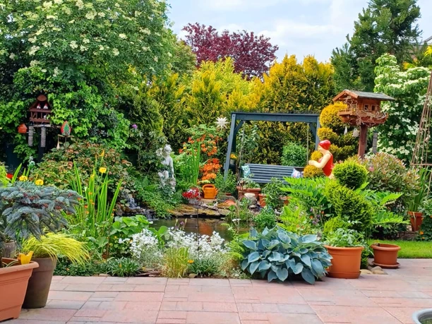 IMG-20240525-WA0016.jpg Ein liebevoll angelegter Garten mit üppiger Pflanzenpracht und einer einladenden Sitzbank am Teich.