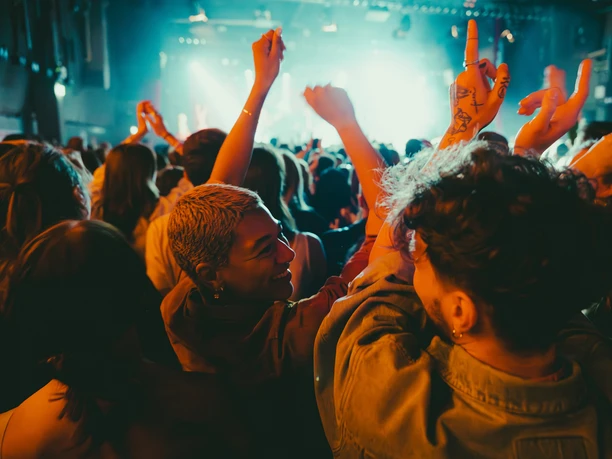 c/o pop in Cologne A lively crowd at a concert, dancing and celebrating.