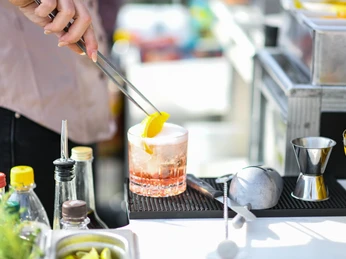 ESG_SummerStart2021_SZW_161.jpg Eine Frau bereitet einen Cocktail in einem kleinen Glas vorA woman is preparing a cocktail in a small glass