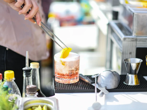 ESG_SummerStart2021_SZW_161.jpg Eine Frau bereitet einen Cocktail in einem kleinen Glas vor