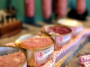 Kruegers_Frühstücksbuffet_Wurst_02.jpg Verschiedene Wurstsorten in Dosen auf Holztisch, im Hintergrund hängende Wurststangen.Various types of sausage in tins on a wooden table, sausage sticks hanging in the background.Forskellige typer pølser i dåser på et træbord, pølsepinde hænger i baggrunden.Verschillende soorten worst in blikken op een houten tafel, worststicks hangen op de achtergrond.