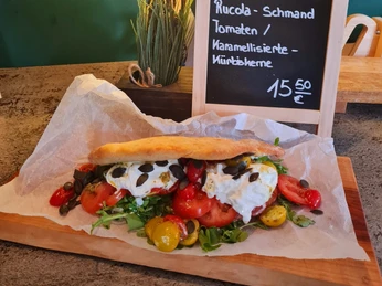 Kruegers_Sommergerichte_Burrate-Sandwich - Kopie.jpg Frisches Burrata-Sandwich auf Ciabatta mit Rucola, Tomaten und karamellisierten Kürbiskernen.Fresh burrata sandwich on ciabatta with rocket, tomatoes and caramelized pumpkin seeds.Frisk burrata-sandwich på ciabatta med rucola, tomater og karamelliserede græskarkerner.Broodje verse burrata op ciabatta met rucola, tomaatjes en gekarameliseerde pompoenpitten.
