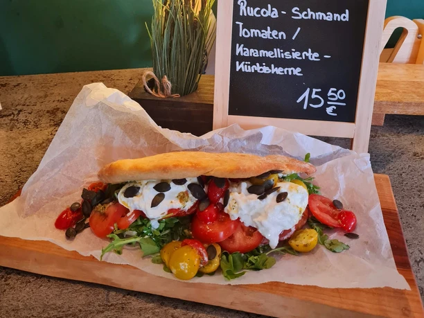 Kruegers_Sommergerichte_Burrate-Sandwich - Kopie.jpg Frisches Burrata-Sandwich auf Ciabatta mit Rucola, Tomaten und karamellisierten Kürbiskernen.