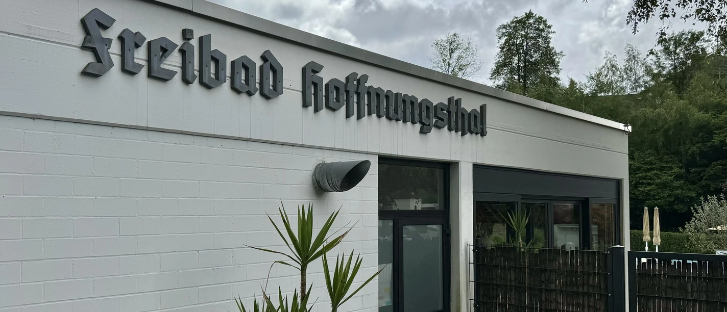 Freibad Hoffnungsthal Eingang zum "Freibad Hoffnungstal" mit moderner Architektur und umgebendem grünen Gartenflair.