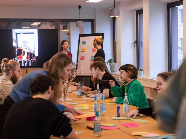 Das Ultra Loft 3.jpg A group of people in a meeting with block seating