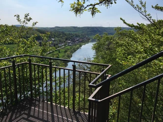 Weser-Skywalk Würgassen Aussichtsplattform mit Blick auf den Fluss Weser, umgeben von grünen Hügeln und üppigem Laub.
