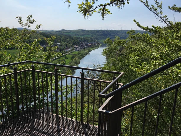 Weser-Skywalk Würgassen Aussichtsplattform mit Blick auf den Fluss Weser, umgeben von grünen Hügeln und üppigem Laub.