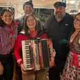 Wally.jpg Eine fröhliche Gruppe von Menschen in traditioneller bayerischer Kleidung mit einer Akkordeonspielerin.