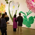 Museumsnacht-Koeln-Inga-Kamphausen_3.jpg Menschen betrachten große bunte Blumenmotive an einer Museumswand während einer Ausstellung