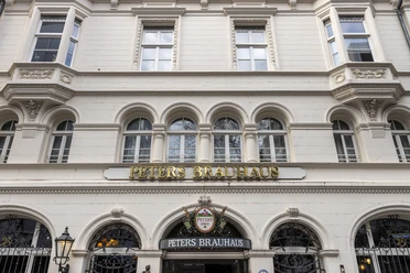 Peters Brauhaus Peters Brauhaus mit seinen historischen weißen Fassaden und goldener Beschriftung in Köln.