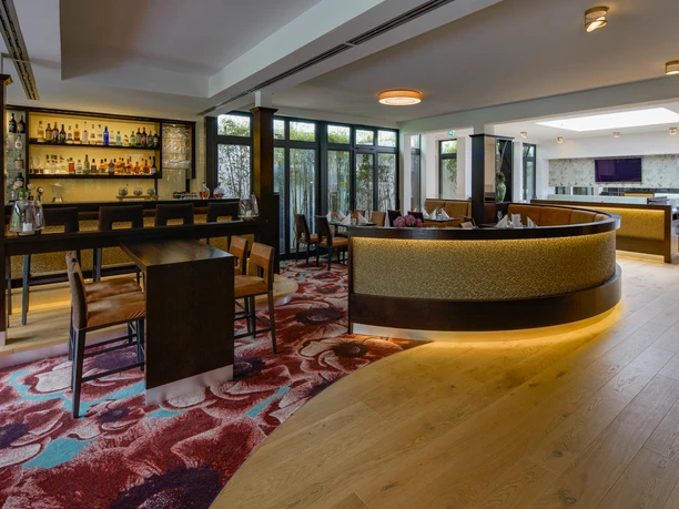 Restaurant merk.Mahl im Essensio Hotel in Erkrath Modernes Restaurant mit geschwungenem Tresen, bunter Teppich und einladender Atmosphäre im Essensio Hotel.