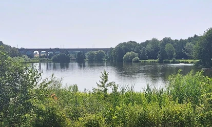 Obersee_CC_BY_SA_BadSalzuflen_KerstinPaar.jpg Ein Viadukt überspannt einen ruhigen See mit umgebender Bewaldung und dichter Vegetation.