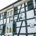 Biergarten Neuemühle Restaurant mit Fachwerkfassade, grünen Fensterläden und altem Gasthaus-Charme.