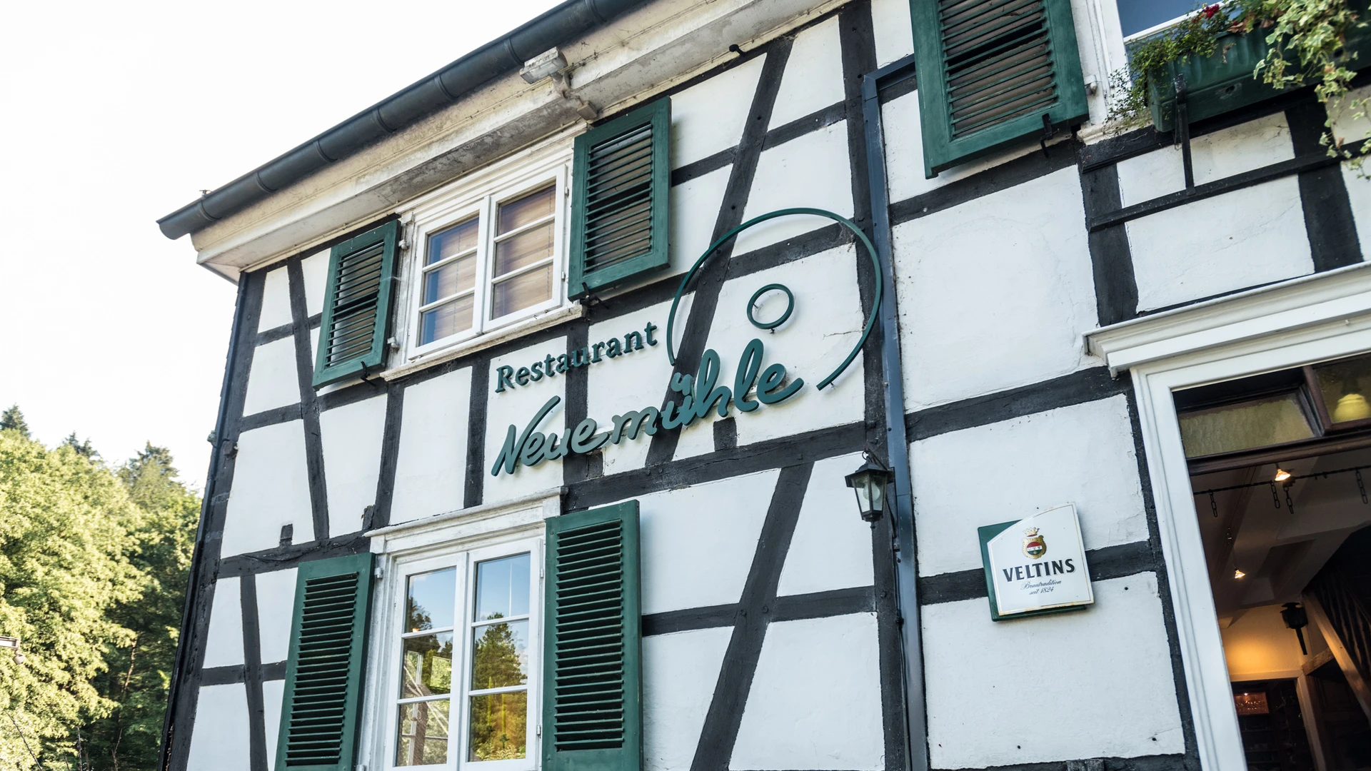 Restaurant mit Fachwerkfassade, grünen Fensterläden und altem Gasthaus-Charme.