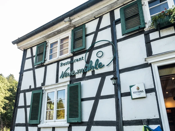 Biergarten Neuemühle Restaurant mit Fachwerkfassade, grünen Fensterläden und altem Gasthaus-Charme.
