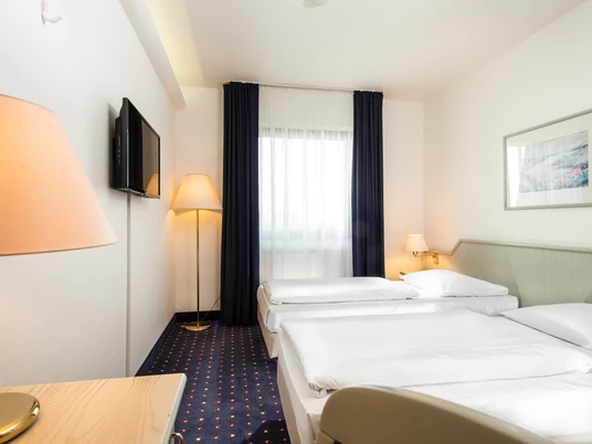 Hotelzimmer im Wyndham Garden Düsseldorf Mettmann Helles Hotelzimmer im Wyndham Garden Düsseldorf Mettmann mit zwei Einzelbetten und moderner Einrichtung.